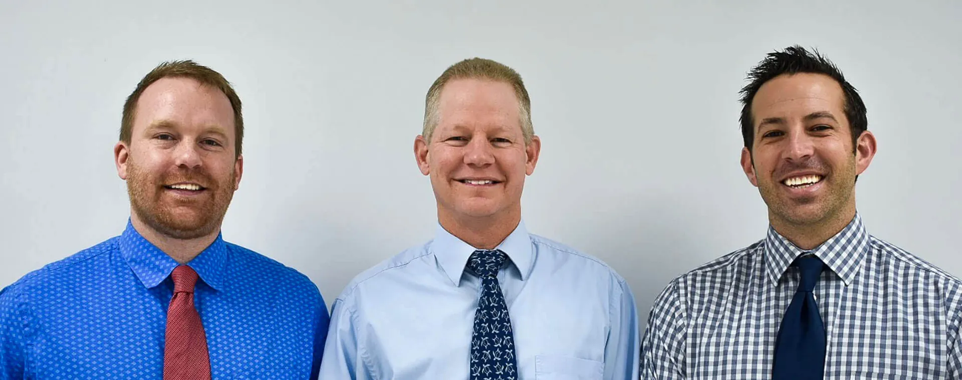 Three Eastland Companion Animal Hospital veterinarians standing together in dress shirts and ties